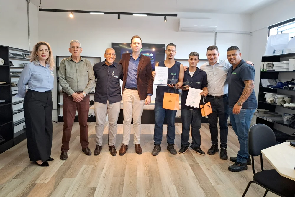 Grupo posando para foto em showroom, com produtos nas prateleiras ao fundo