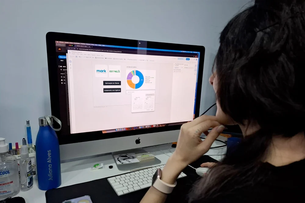 Profissional diante de um iMac com o layout de um site na tela