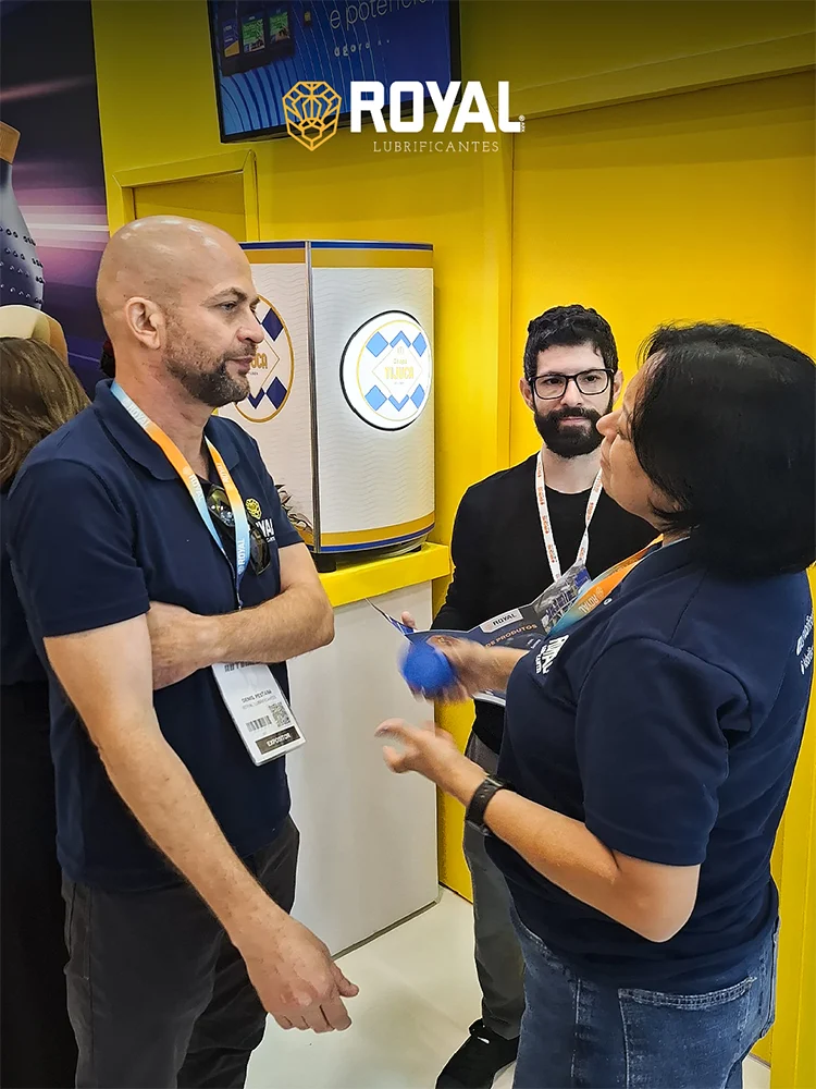 Atendimento a um visitante no estande amarelo da Royal, em feira do setor